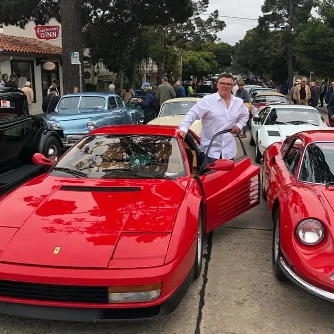 Donnie Callaway beside a red Ferrari at an automotive gathering